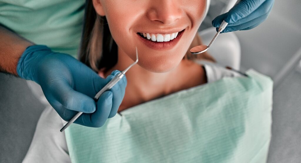 Patient sitting in the dental chair while the dentist is checking for cavities